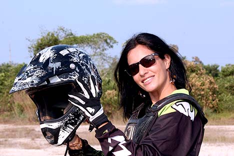 Woman sitting on Motorcycle holding motorcycle helmet