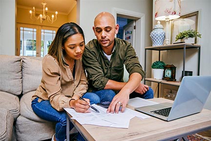 Couple at kitchen table going over their finances